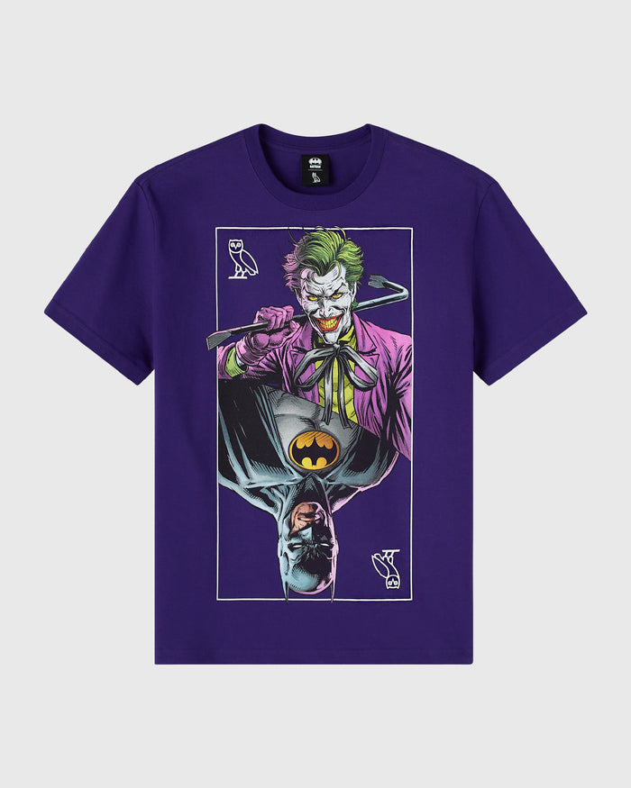 Purple t-shirt featuring mirrored graphic of Joker character with green hair and pink suit, Batman logo, and owl symbols.