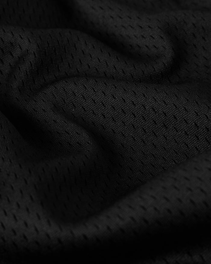 Close-up of black mesh fabric with textured weave pattern and folded sections.