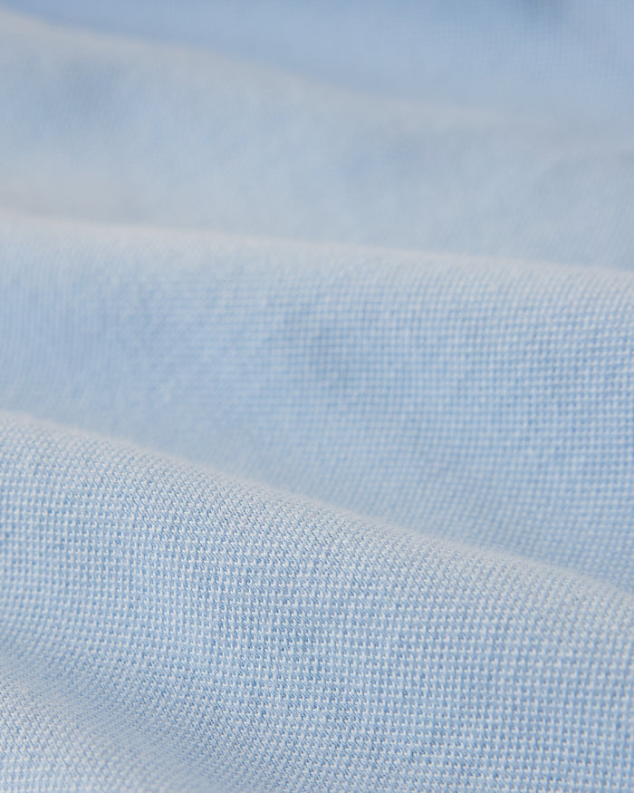 Light blue polo shirt fabric with textured weave detail.