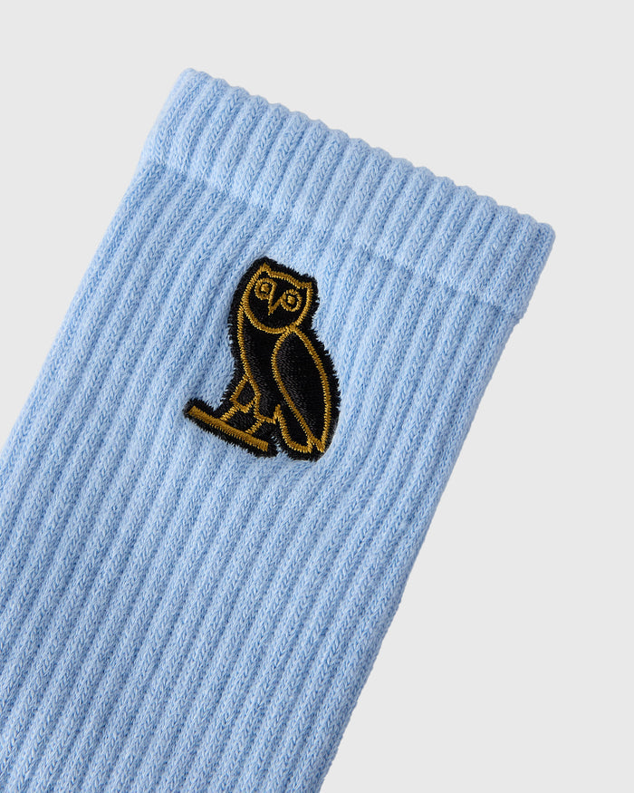 Light blue ribbed sock with black and gold embroidered owl patch.