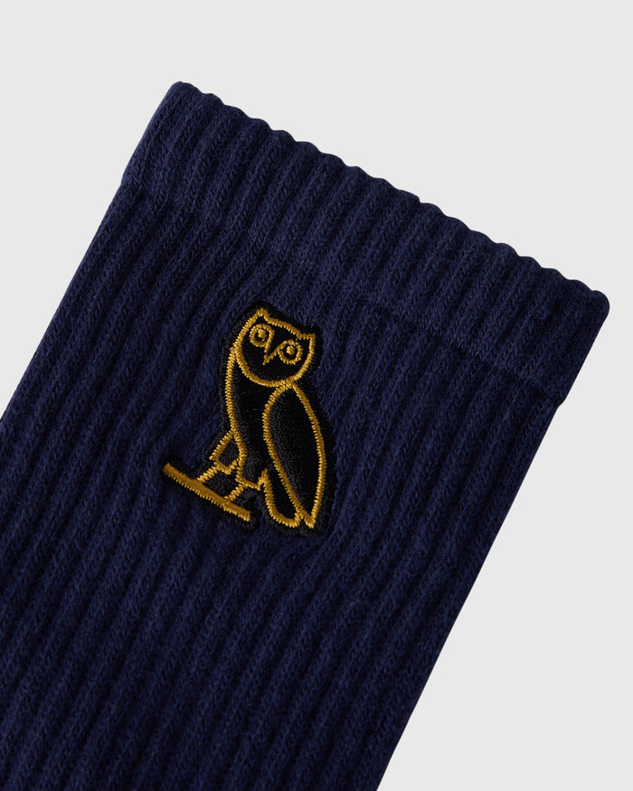 Navy ribbed socks with yellow owl embroidered logo on the leg.