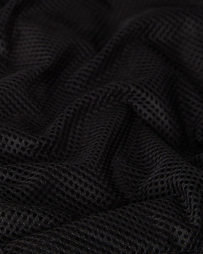 Black swim short with textured mesh fabric and draped folds.