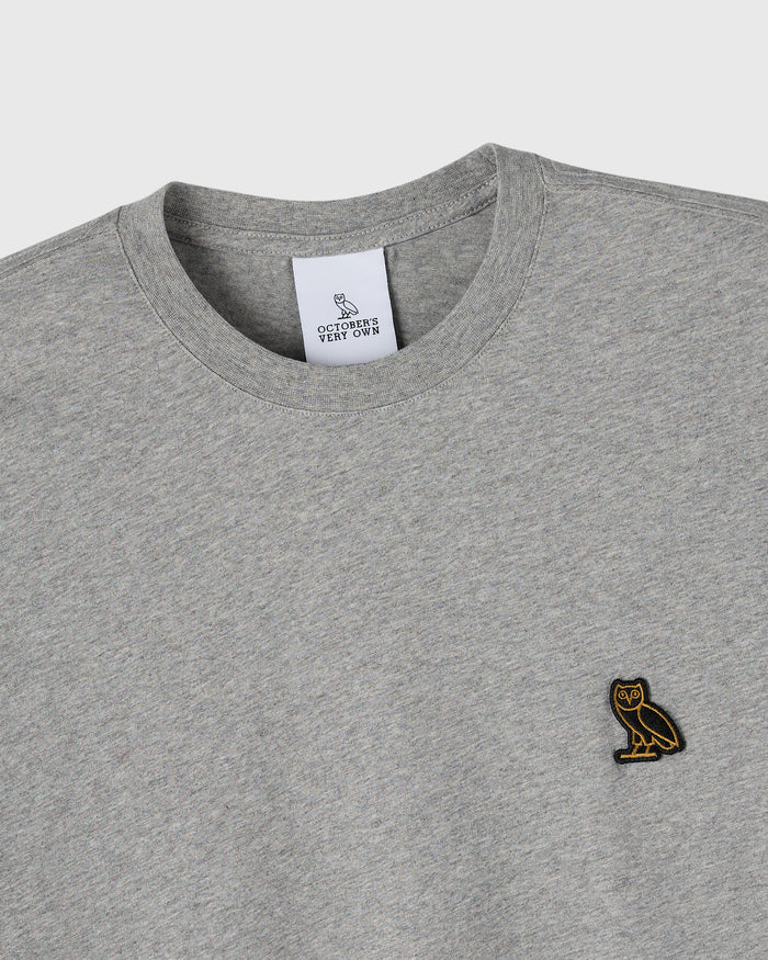 Heather grey crewneck t-shirt with small embroidered owl logo on chest and brand label at neckline.