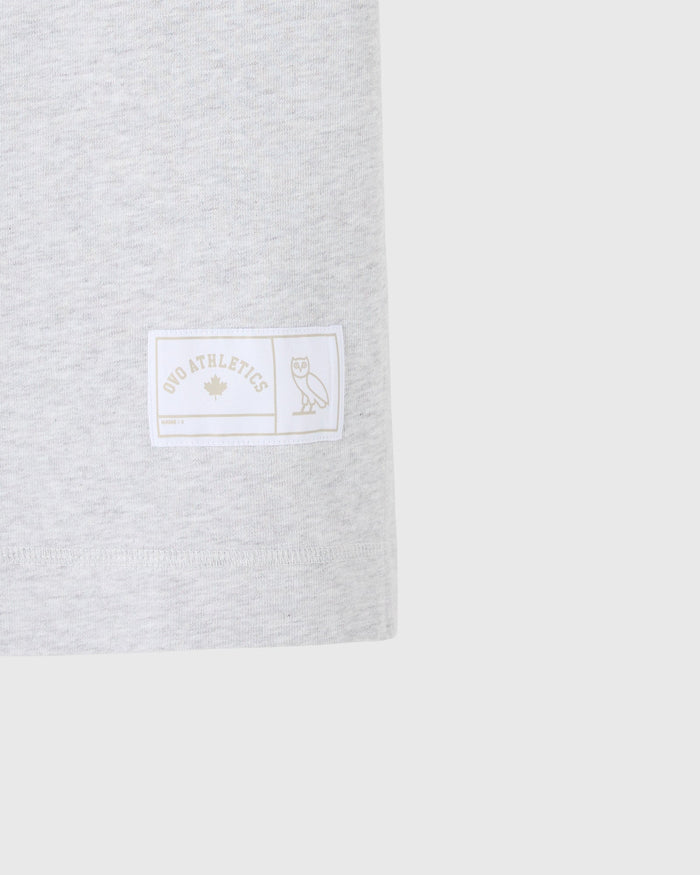 Ash heather grey t-shirt with white woven label featuring "OVO Athletics" text and owl graphic on chest.