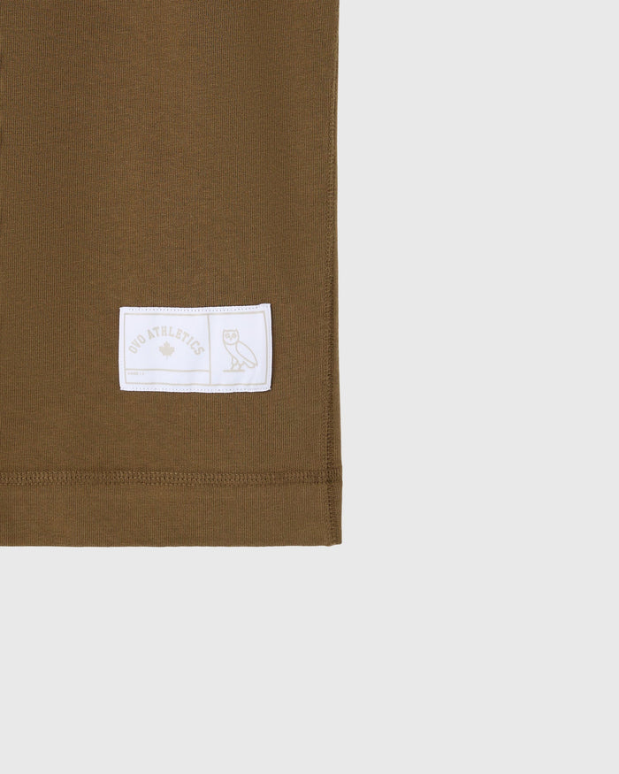 Moss-colored heavyweight cotton tee with white woven label featuring owl mascot graphic.