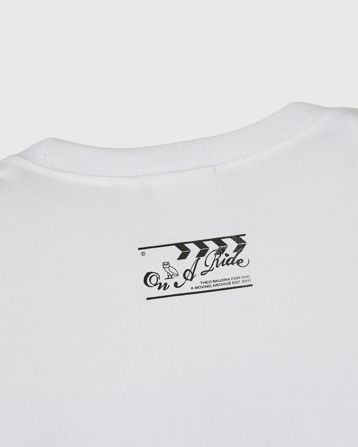 White crewneck t-shirt with black graphic print reading "On a Pride" and archival text on chest.