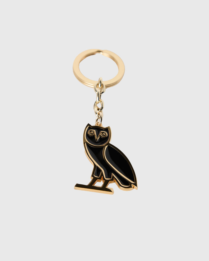 Gold-toned metal keychain with black enamel owl charm attached to a split ring.