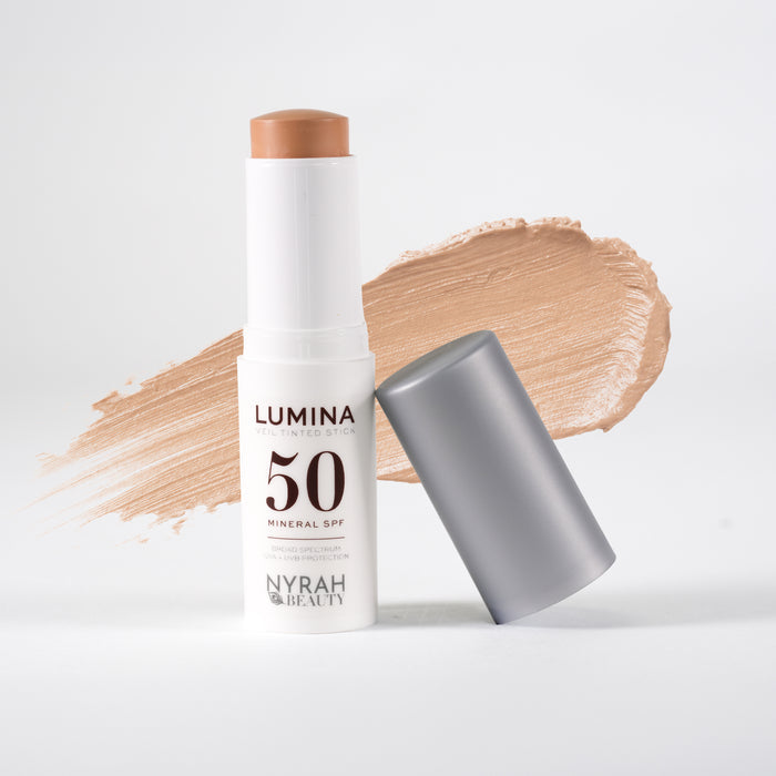 Nyrah Beauty Lumina 50 Mineral SPF stick sunscreen with its cap off, displayed next to a swipe of the beige-tan cream formula on a clean white background.