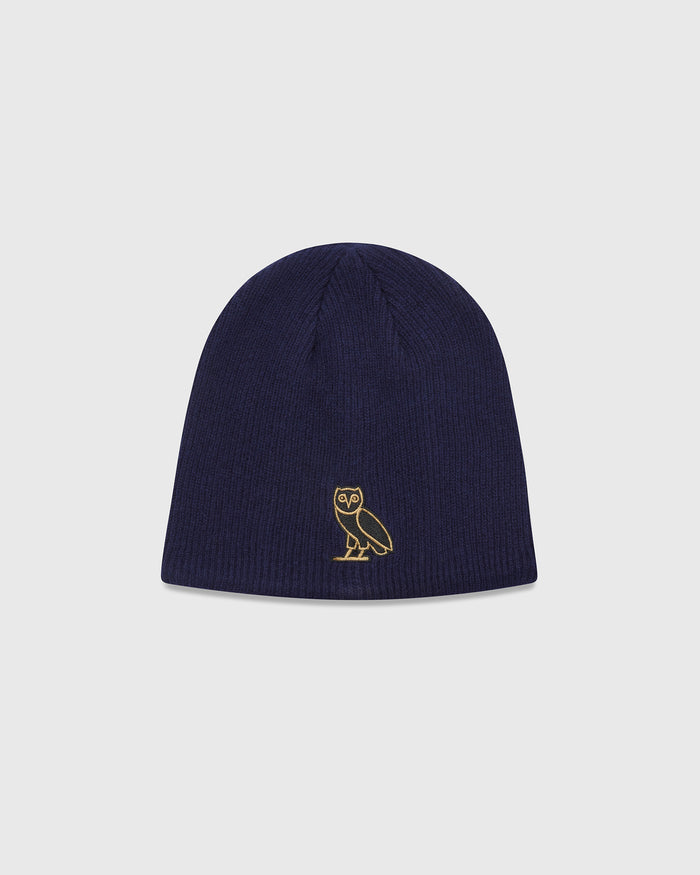 Navy ribbed beanie with gold owl embroidered on front.