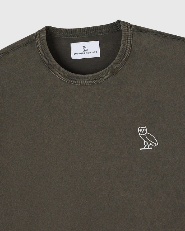 Deep olive crewneck t-shirt with small white owl embroidery on chest and brand label at neckline.