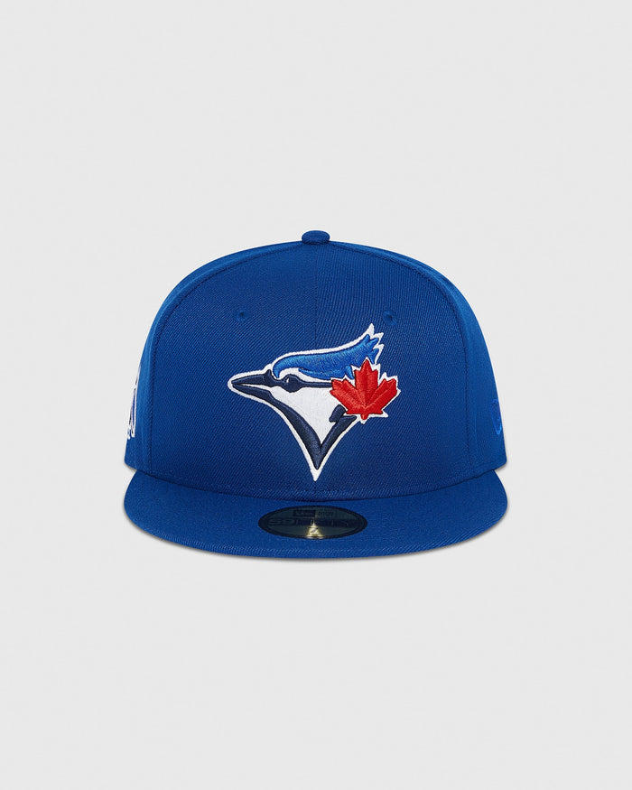 Blue fitted cap with Toronto Blue Jays bird and maple leaf logo embroidered on front.