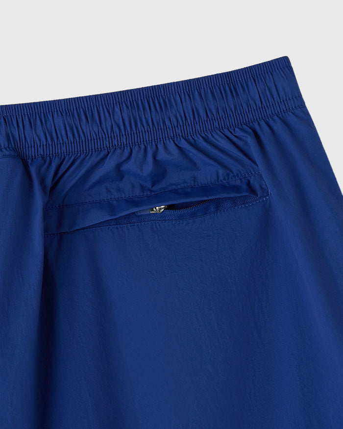 Midnight blue nylon track short with elasticated waistband and side zip pocket detail.