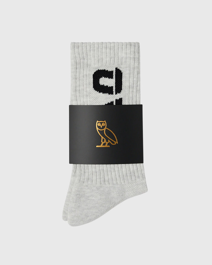 Light grey ribbed crew socks with black text design and gold owl logo on black band.