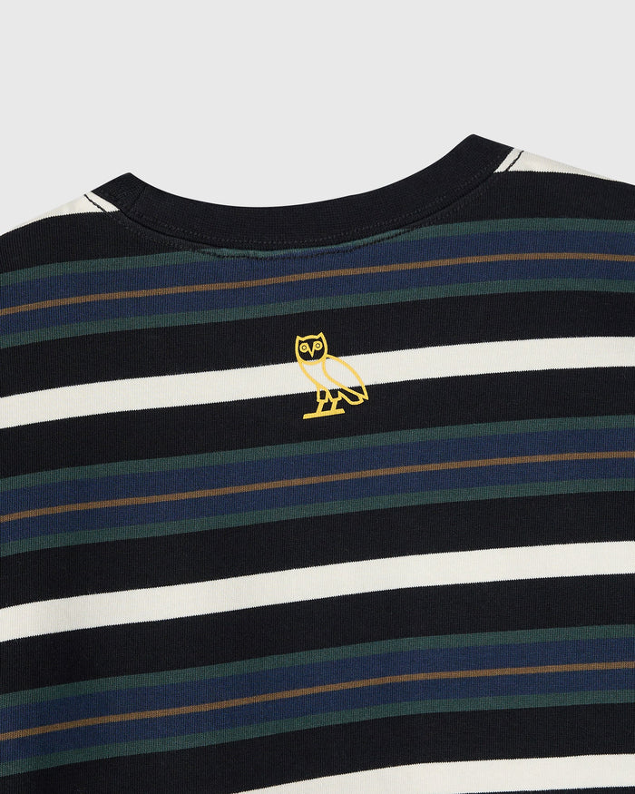 Black long-sleeve tee with horizontal stripes in white, navy, and green, featuring a yellow owl emblem on the chest.