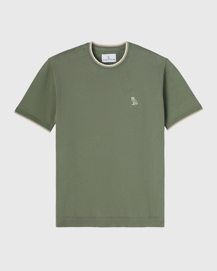Sage green short-sleeve sweater t-shirt with cream ribbed neckline and small owl embroidery on chest.