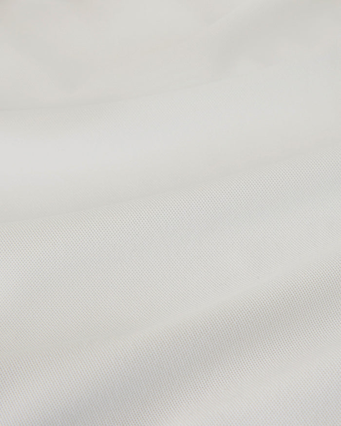 White piqué polo shirt with textured knit fabric detail.