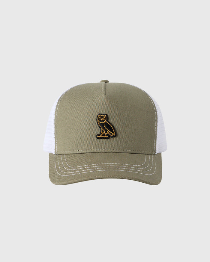 Khaki and white trucker hat with embroidered owl logo on front panel and contrasting topstitching on bill.