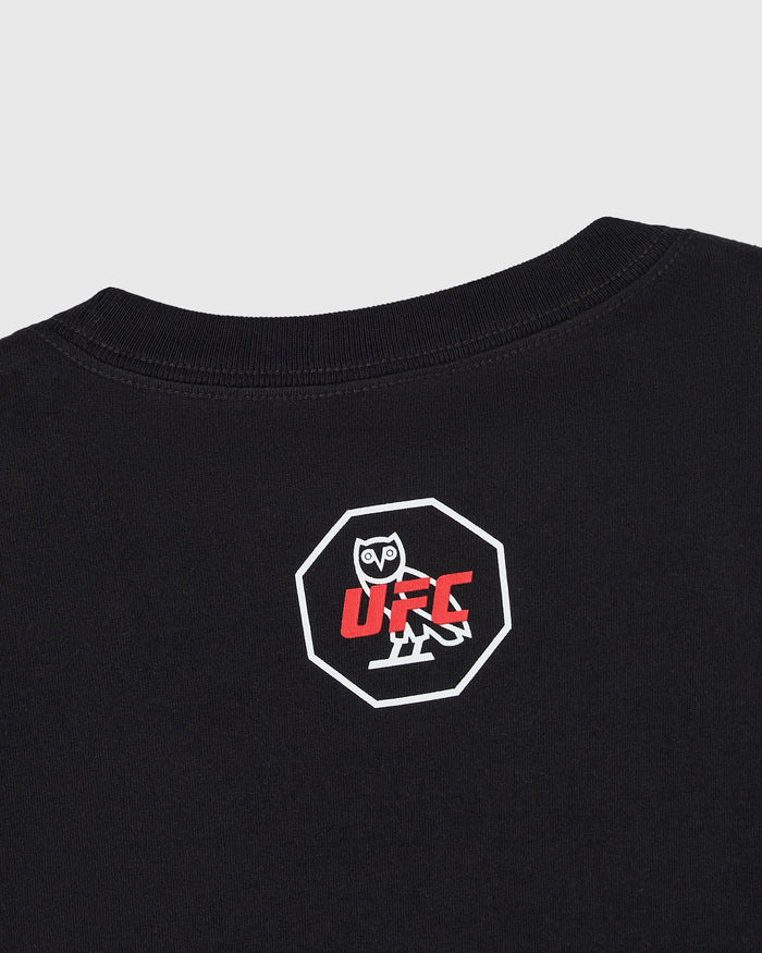 Close up of back of black t-shirt with UFC octagon graphic featuring an owl character in a white octagon logo with red text on chest.