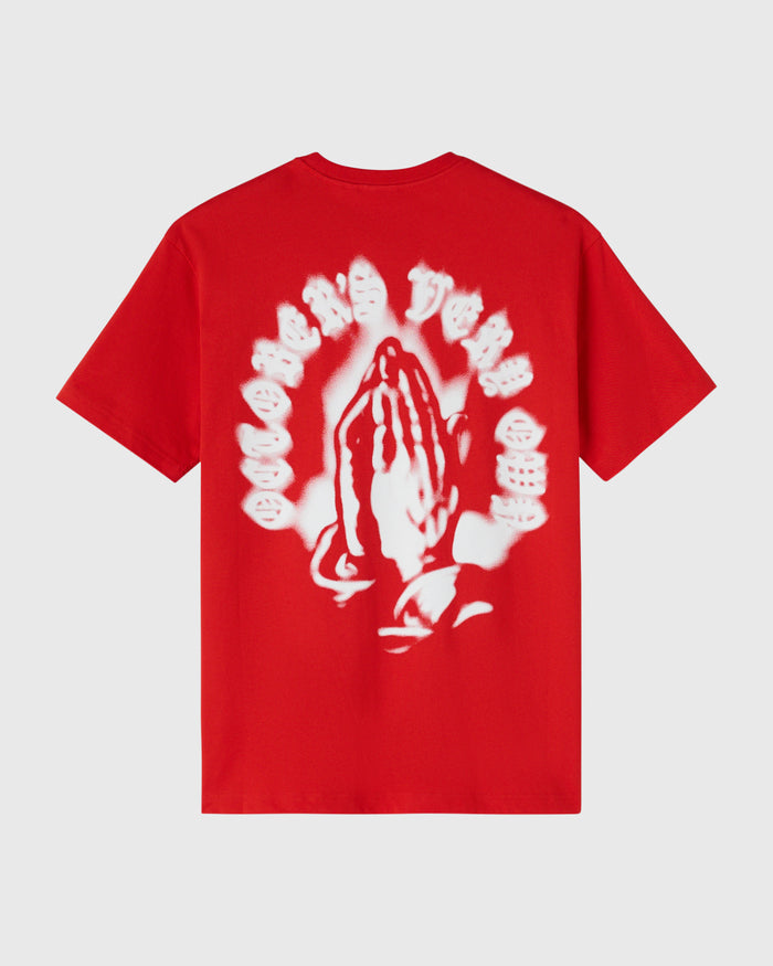 Red t-shirt with airbrushed white graphic featuring praying hands surrounded by circular text design on back.