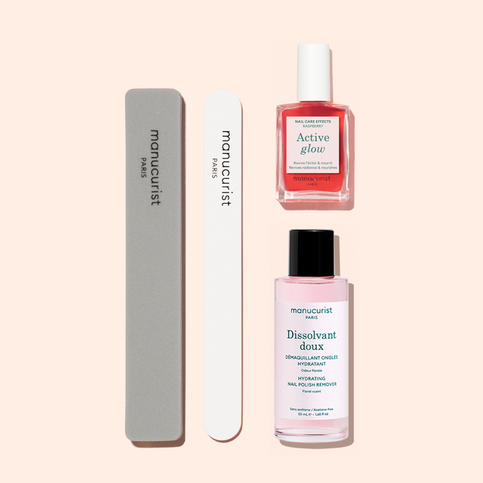 The Manucurist Active Discovery Kit features two nail files, a pink bottle of nail polish labeled "Active Glow," and a pink bottle of nail polish remover labeled "Dissolvant Doux," all beautifully arranged on a light beige background—essential tools for achieving a flawless manicure and elevating your daily nail care routine.