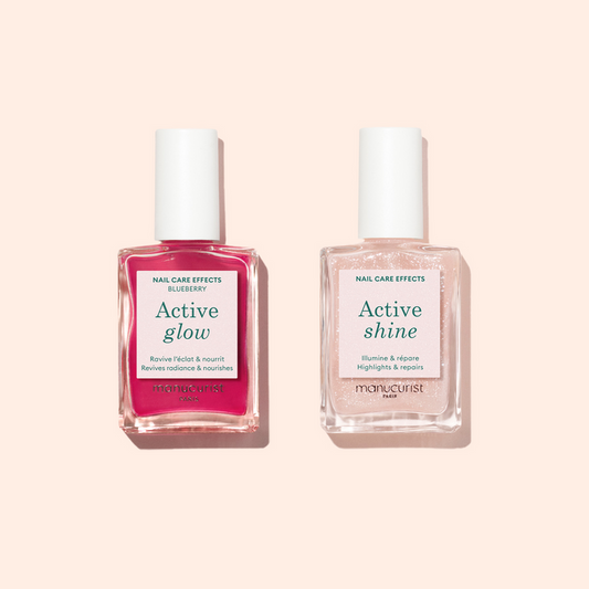 Two bottles of Manucurist's Active™ Duo nail care set—pink Active Glow and clear Active Shine—are displayed on a light beige background, ideal for natural nail repair and care.