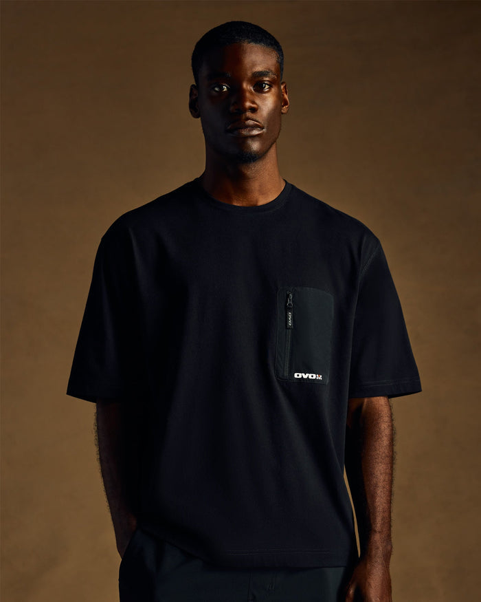 Black short-sleeve t-shirt with chest pocket featuring zippered detail and brand logo.