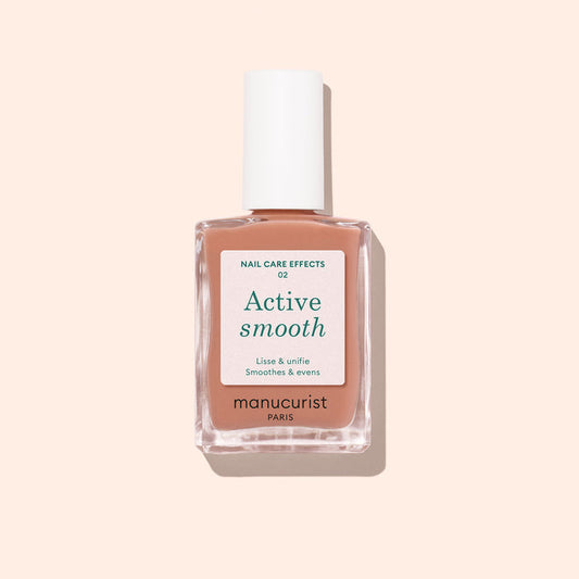 A bottle of Manucurist Active™ Smooth 02 nail care polish with a white cap, displayed against a pale peach background. The white label with green and black text emphasizes this advanced CC Polish as an ideal treatment for healthier-looking nails.