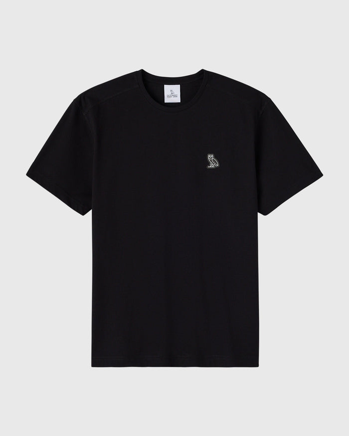 Black crew neck t-shirt with small owl emblem on chest.