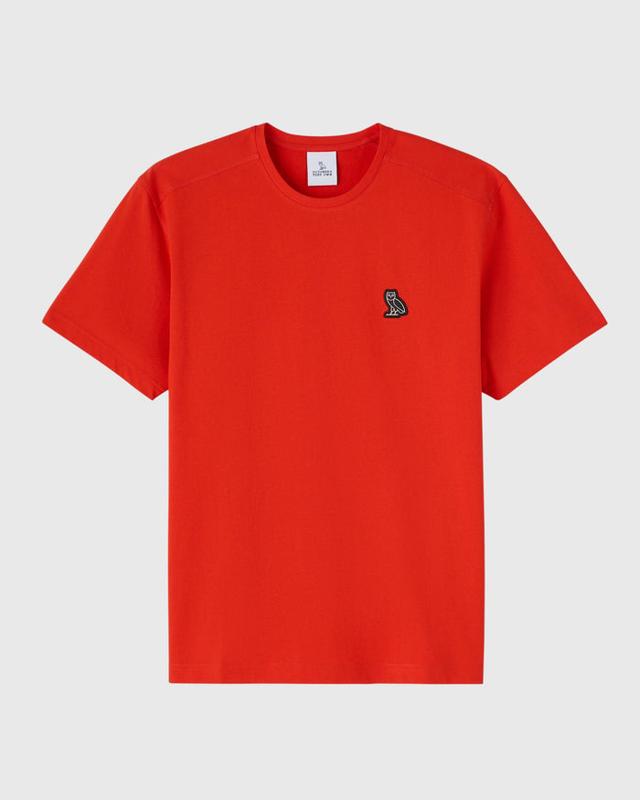 Signal orange short-sleeve crewneck tee with small embroidered owl logo on chest.
