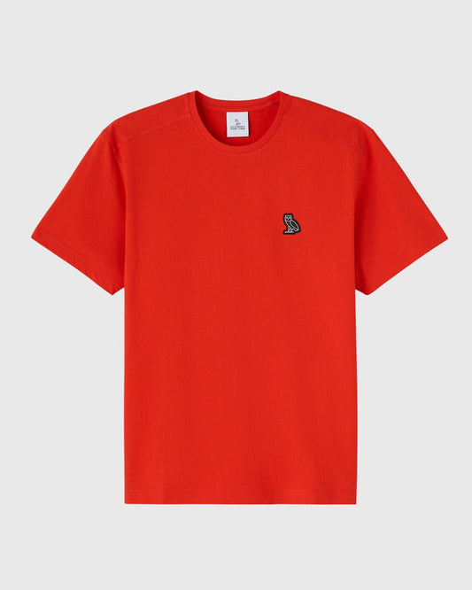 Signal orange short-sleeve crewneck tee with small embroidered owl logo on chest.