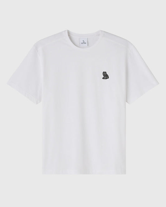 White crewneck t-shirt with small black owl emblem on chest.