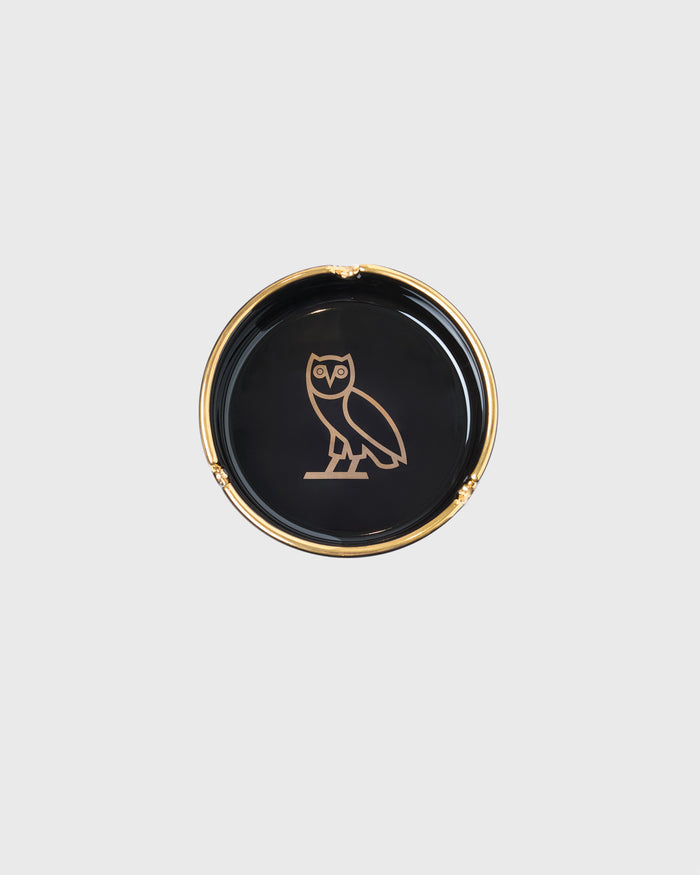 Black ceramic ashtray with gold rim and gold owl illustration on the center base.