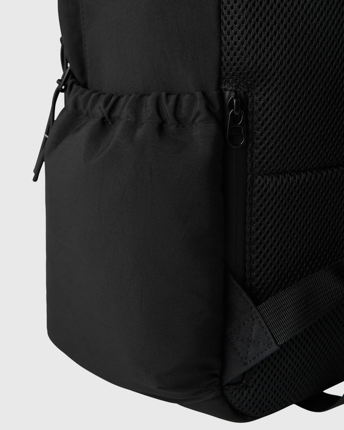 Black backpack with padded straps, mesh side panel, and zippered pocket detail.