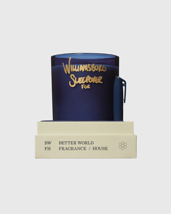 Dark blue candle with gold "Williamsburg Sleepover For" text and light cream packaging labeled Better World Fragrance House.