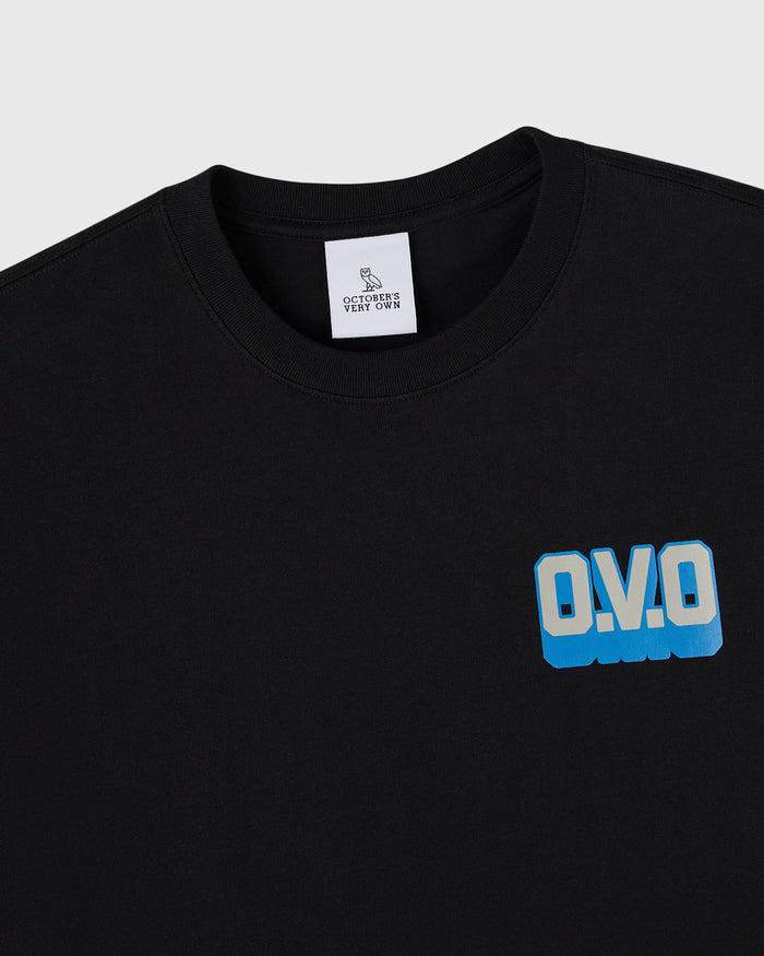 Black crewneck t-shirt with blue "O.V.O" wordmark print on chest and white brand label at neckline.