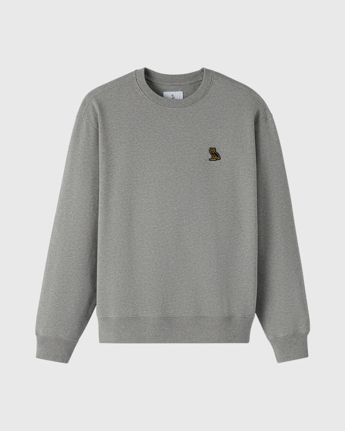 Heather grey crewneck sweatshirt with small embroidered owl logo on chest.