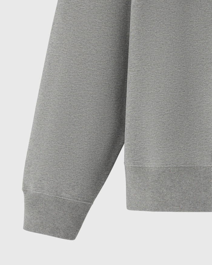 Heather grey crewneck sweatshirt with ribbed cuffs and hem, shown from torso detail view.