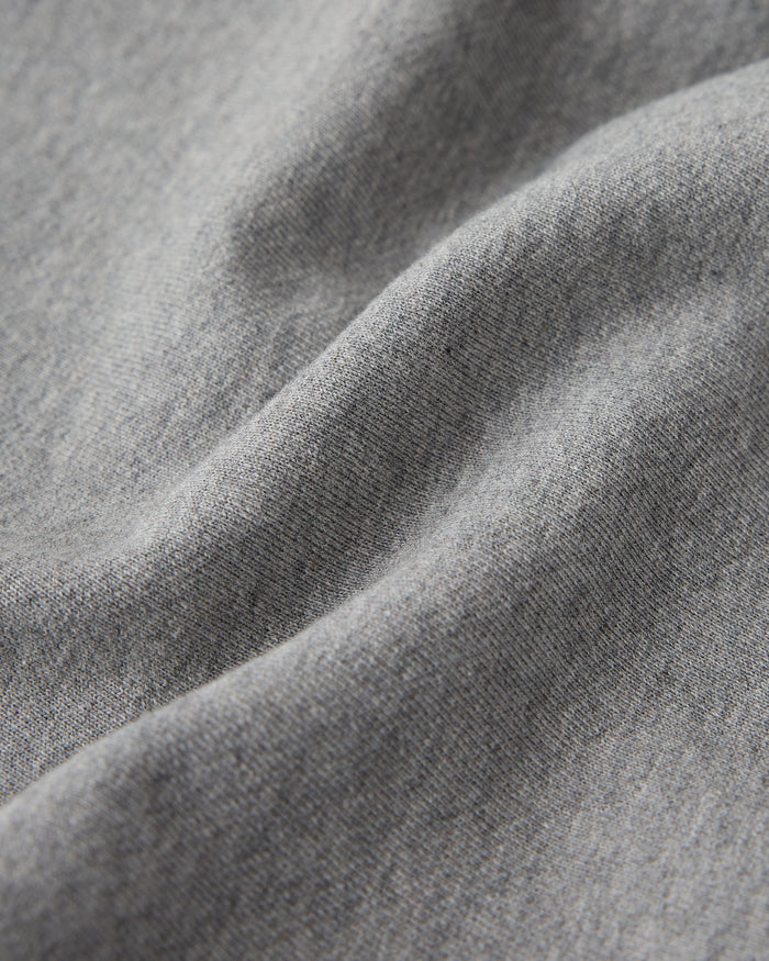 Heather grey sweatshirt fabric with ribbed texture and natural folds showing the material's drape.