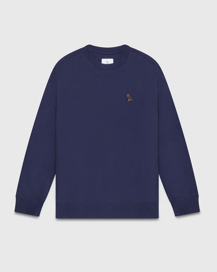 Navy crewneck sweatshirt with small embroidered owl logo on chest.