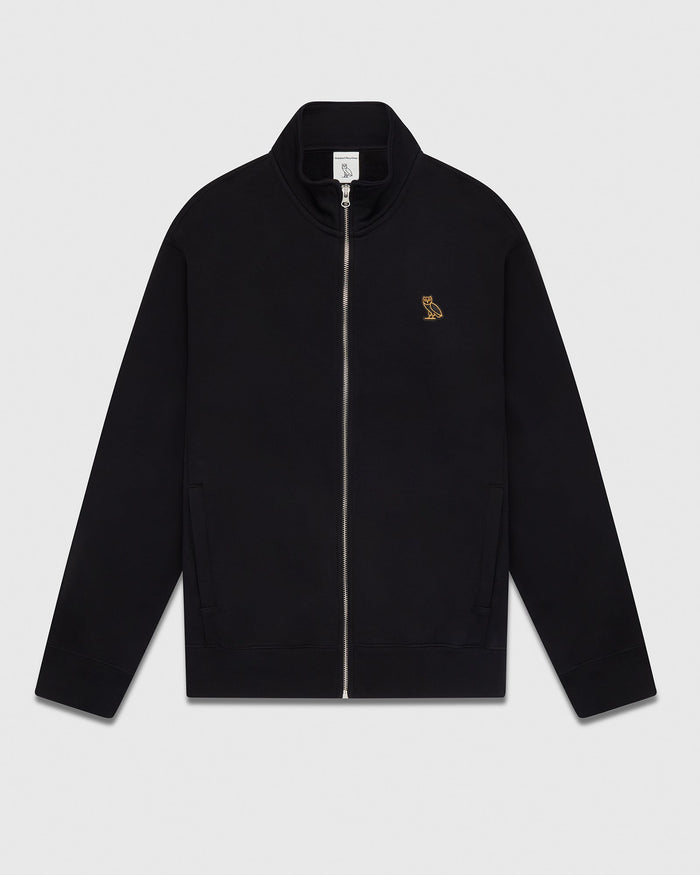 Black full-zip track jacket with gold embroidered owl logo on chest and side pockets.