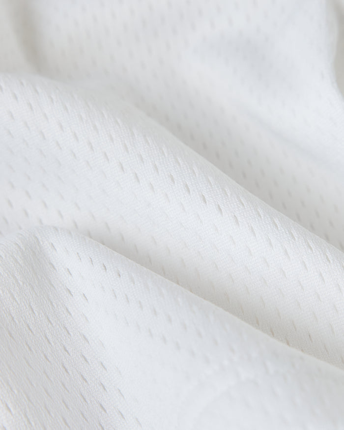 White mesh fabric with textured weave pattern and draped folds.