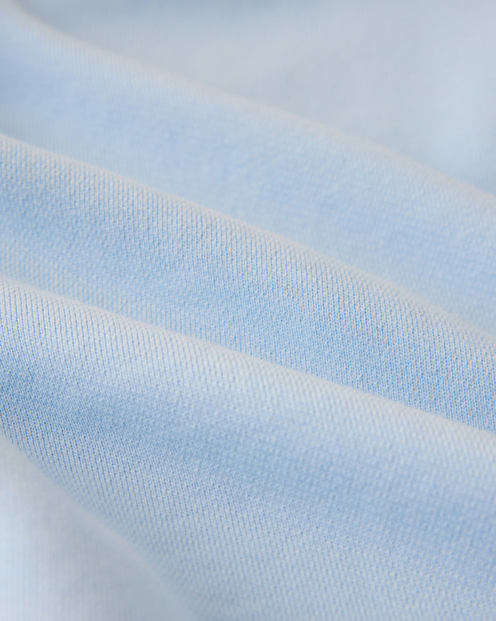 Light blue sweatshirt fabric with textured knit surface and visible ribbed sections.