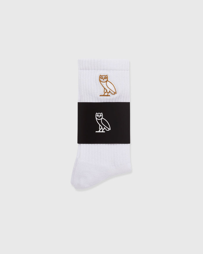 White crew socks with brown and white owl embroidery on ribbed cuff.