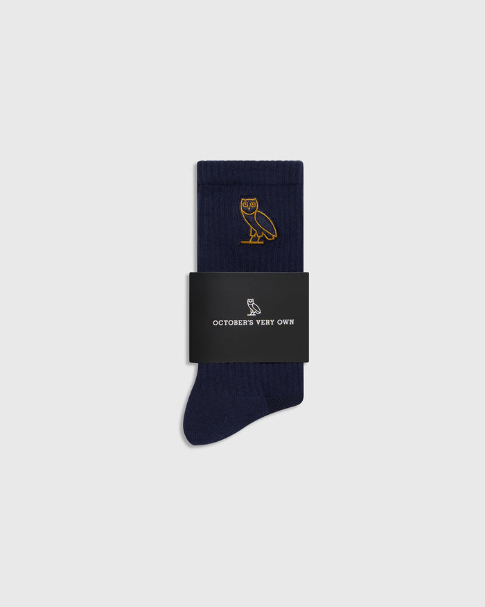 Navy blue ribbed socks with gold owl embroidery, packaged in black band with "October's Very Own" branding.