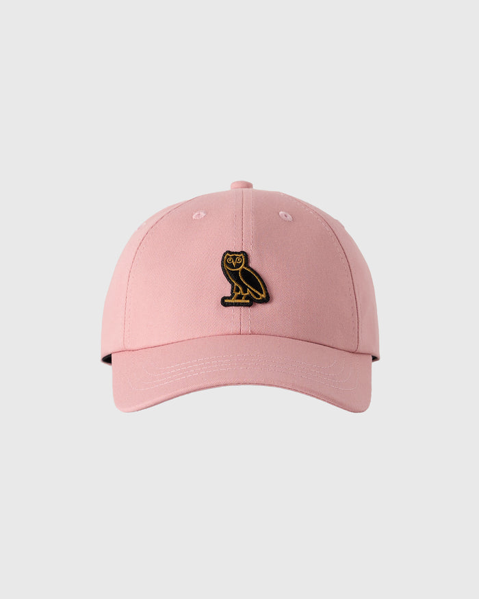 Pink baseball cap with black and gold owl emblem on front.