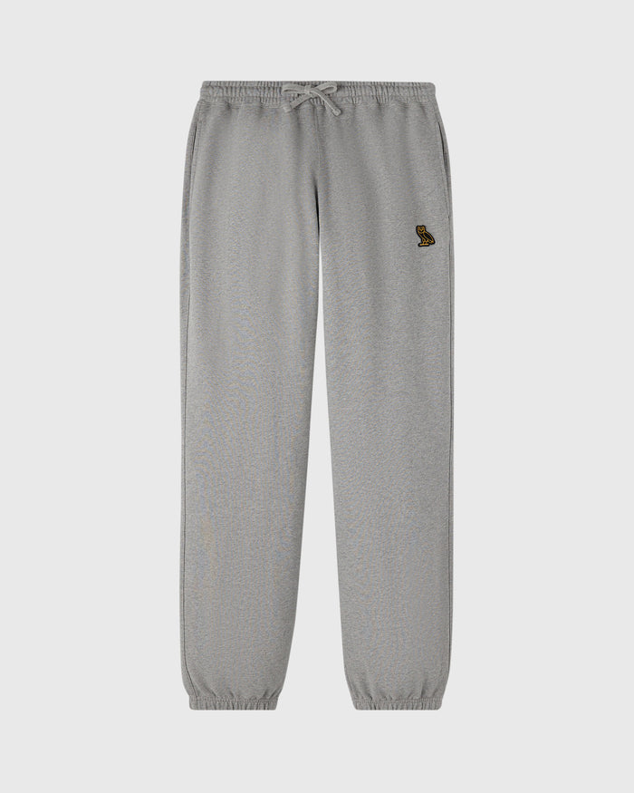 Heather grey sweatpants with drawstring waist, small embroidered logo on left thigh, and ribbed cuffs at ankles.