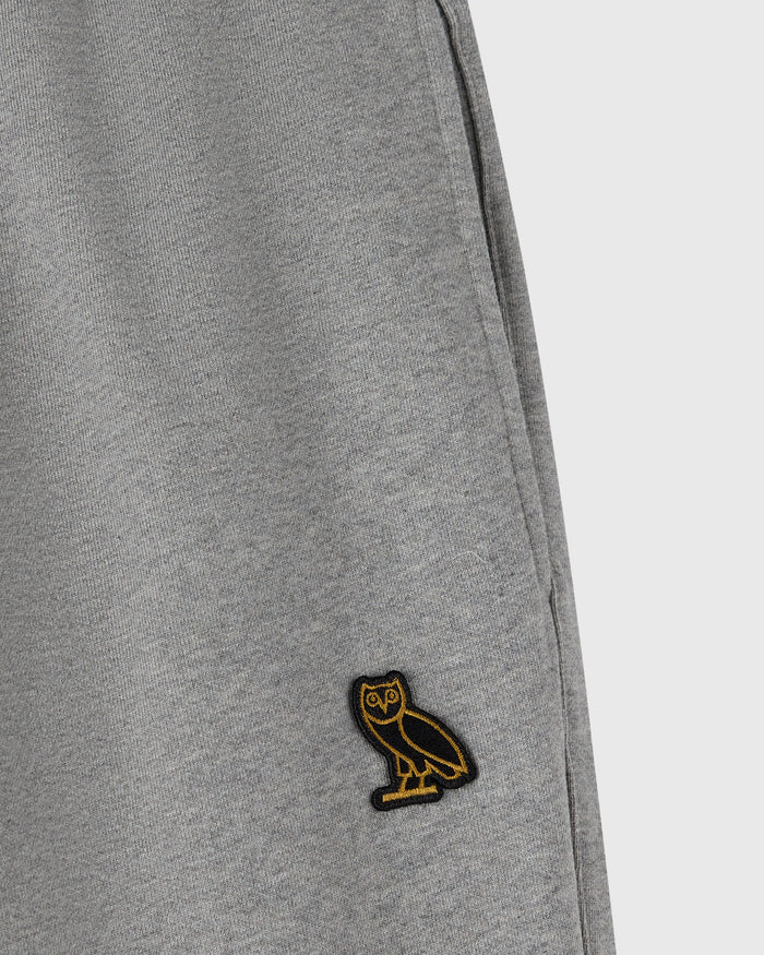 Heather grey sweatpant with ribbed texture and small embroidered owl logo on leg.