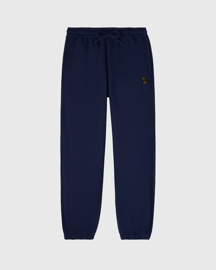 Navy sweatpants with drawstring waist and small embroidered logo on thigh.