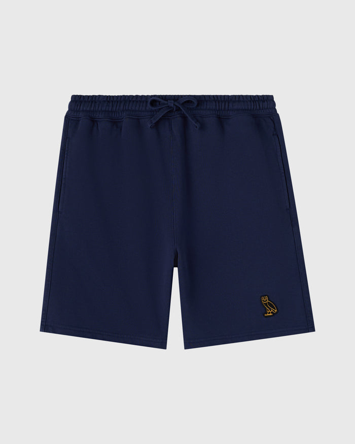 Navy sweatshorts with drawstring waist and small gold bird embroidery on leg.