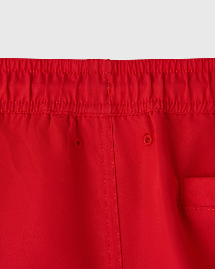 Red swim shorts with elastic waistband, center front seam, and side pocket detail.